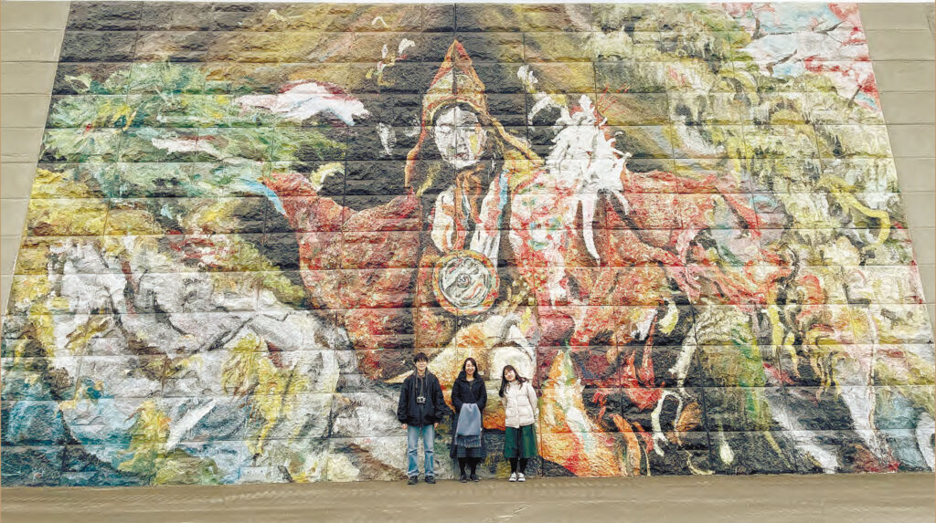 高さ9メートルの防潮堤に雄勝法印神楽をモチーフに描かれた壁画「岩戸開｜The Opening」