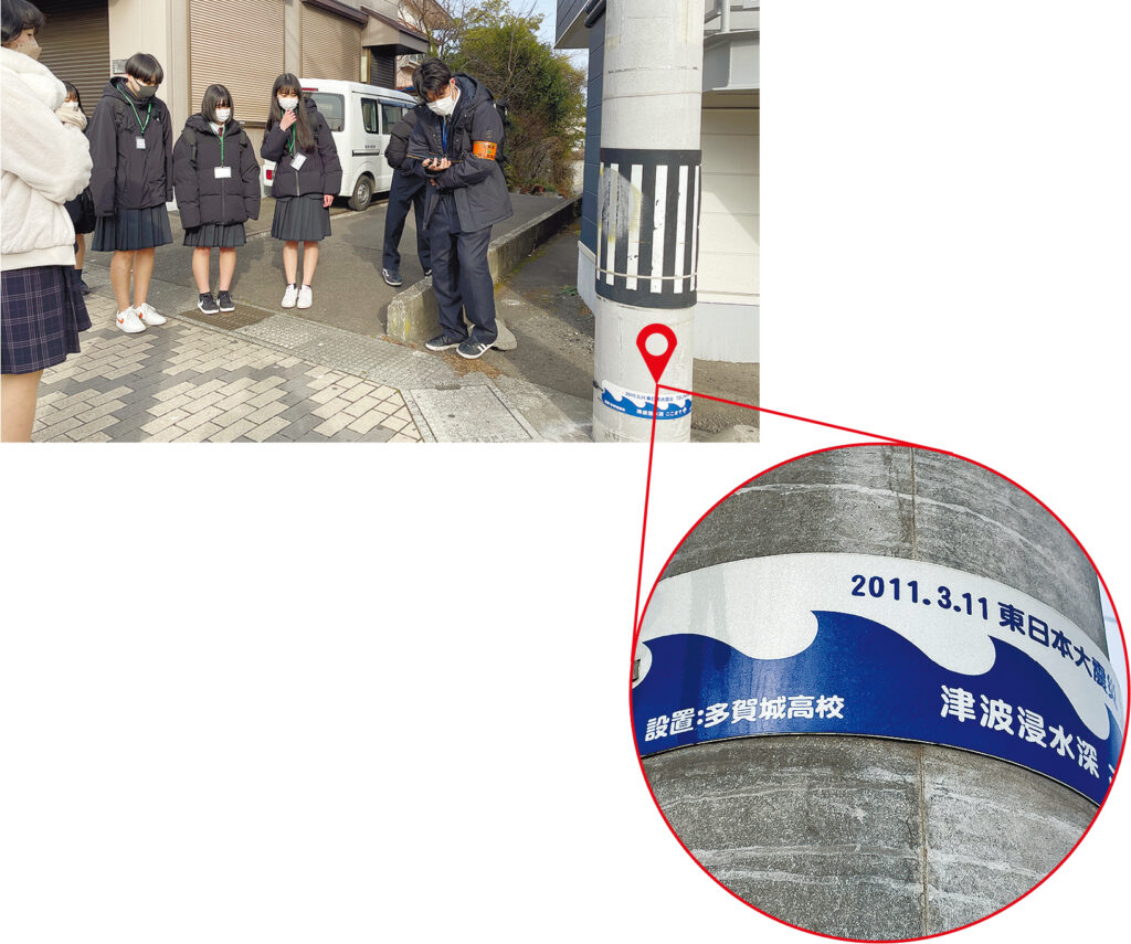 多賀城高校が設置した「津波波高標識」。沿岸部では電信柱の上の方に見えるが、駅に近づくにつれて位置が低くなっていくのが分かる